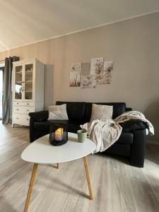 a living room with a black couch and a table at Ferienhaus Kleine Auszeit in Idar-Oberstein