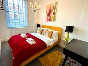 a bedroom with a bed with a red blanket at Bristol City Stays - Cabot Circus in Bristol