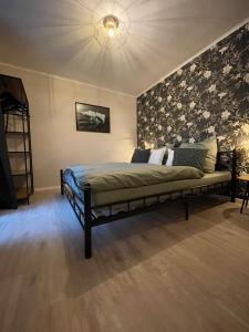 ein Schlafzimmer mit einem Bett mit floralen Akzenten in der Unterkunft Ferienhaus Kleine Auszeit in Idar-Oberstein