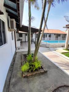 a courtyard with palm trees and a swimming pool at Itapira Flats - Apto 7 in Imbituba