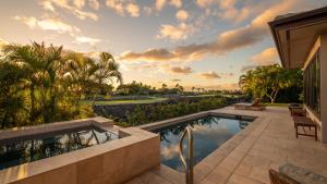 a swimming pool in front of a house at Mauna Lani Luxury Vacation Villas - CoralTree Residence Collection in Waikoloa
