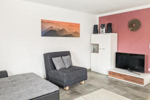a living room with a chair and a television at Allgäu-Genuss in Halblech