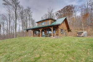 a log cabin on a hill with a green roof at Remote Escape Vermont Cabin with Mountaintop Views! 