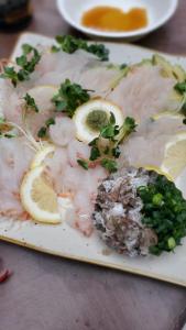 um prato de comida com peixe e fatias de limão em KIRIKUSHI COASTAL VILLAGE - Vacation STAY 37273v em Kure