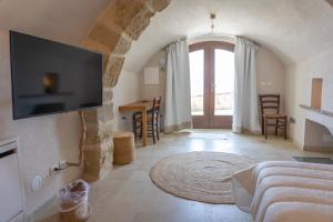 a living room with a tv on a wall at Case al Borgo-Agira Centre-Home Relais in Agira