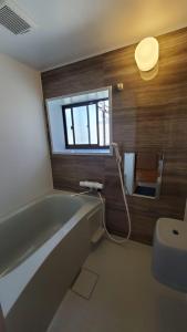a bathroom with a bath tub and a window at KIRIKUSHI COASTAL VILLAGE - Vacation STAY 37273v in Kure