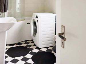 eine Waschmaschine im Bad neben einem Waschbecken in der Unterkunft Holiday home LAHOLM IX in Laholm