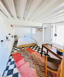 een slaapkamer met een bed, een tafel en een tapijt bij Ocean Home in Essaouira