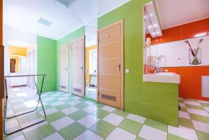 Un baño con paredes verdes y naranjas y suelo de baldosas. en Guest house "Golden Gate 911 ", en Kiev