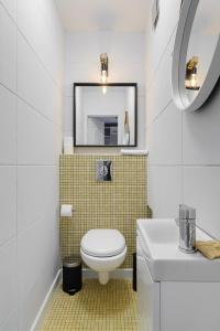 a bathroom with a toilet and a mirror at P&O Apartments Hawajska in Warsaw