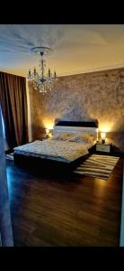 Schlafzimmer mit einem Bett und einem Kronleuchter in der Unterkunft Dominic house in Turda