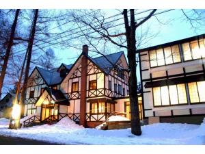 una casa grande con nieve delante en Hotel Montblanc Hakuba - Vacation STAY 97806v en Hakuba