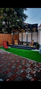 einen Hinterhof mit einem Pavillon und grünem Gras in der Unterkunft Dominic house in Turda