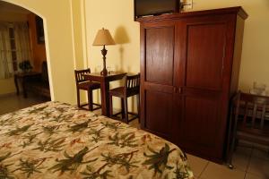 a bedroom with a bed and a cabinet and a desk at Hotel Florencia in San Miguel