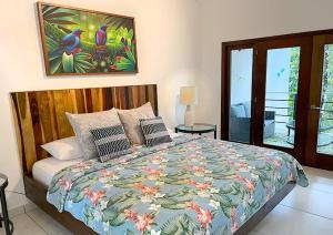 una camera da letto con un letto con un piumone colorato di Aracari Lodge & Jungalows a Middlesex