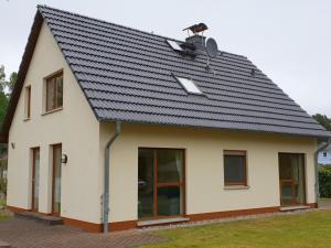 een huis met een zwart dak bij Karlshagen, Ferienhaus am Hasenwinkel in Ostseebad Karlshagen