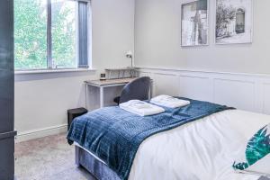 a bedroom with a bed with a chair and a desk at Great Stunning Two Bedroom Apartment With Balcony in Manchester
