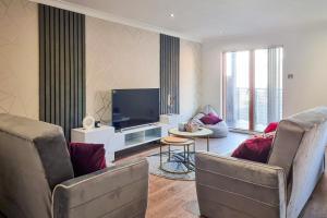 a living room with two chairs and a flat screen tv at Great Stunning Two Bedroom Apartment With Balcony in Manchester