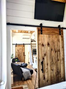 a room with a sliding barn door with a tv on the wall at Tiny Home Big Fun in Knoxville