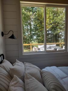 a bed with pillows in a room with a window at Tiny Home Big Fun in Knoxville