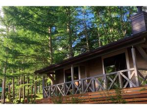 a wooden cabin with a large porch in the woods at Class Vesso Tateshina - Vacation STAY 51898v in Chino