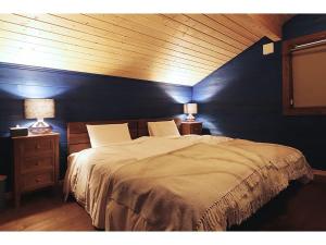 Class Vesso Tateshina - Vacation STAY 51898v في تشينو: غرفة نوم بسرير كبير بجدار ازرق