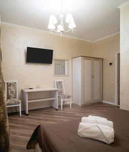 1 dormitorio con 1 cama, escritorio y TV en Safari-Club, en Vínnytsia