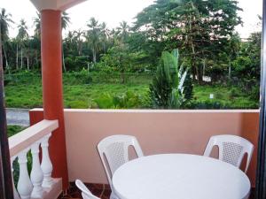 a white table and chairs on a balcony at Casa Lily & Coco in Las Terrenas