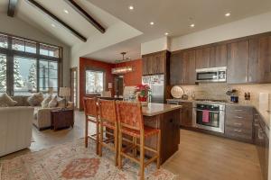 a kitchen with wooden cabinets and a living room at Gondola Getaway- Ski-in Ski-out - Luxury 4 BR, Private Hot Tub, HOA Amenities in Truckee