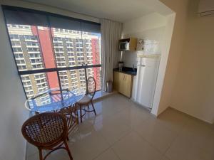 Habitación con mesa, sillas y cocina. en Garvey Park Hotel, en Brasilia