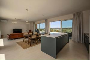 a kitchen and living room with a table and a couch at Santa Lucia - Villa&Boat in Turanj