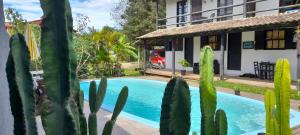 a house with a swimming pool and cactus at Solar da Suzi in Praia do Rosa