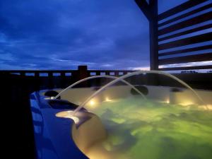 a blue car with a hot tub on a balcony at night at Beautiful Glamping Pod with Central Heating, Hot Tub, Garden, Balcony & views - close to Cairnryan - The Herons Nest by GBG in Glenluce