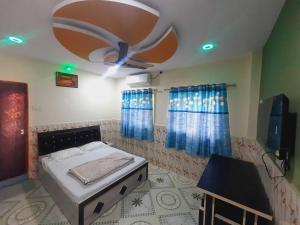 a bedroom with a bed and a ceiling fan at OYO Galaxy Lodge in Partūr