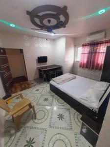 a bedroom with a bed and a desk and a chair at OYO Galaxy Lodge in Partūr