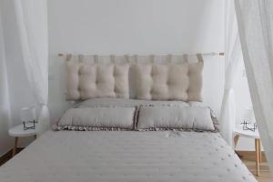 1 dormitorio con 1 cama blanca y cabecero de mechón en appartamento Enrica, en Lovere