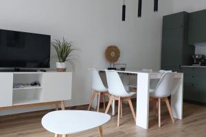 uma sala de jantar com uma mesa branca e cadeiras brancas em appartamento Enrica em Lovere