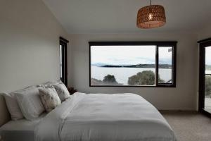 um quarto com uma cama grande e uma janela grande em Eco Waterfront Seclusion - Carlton Bluff House em Primrose Sands