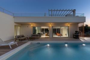 a swimming pool in front of a house at Santa Lucia - Villa&Boat in Turanj