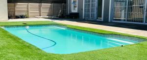 a swimming pool with blue water in a yard at African Haven Guest House in Cape Town