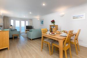 a dining room and living room with a table and chairs at Wavetop in St Ives