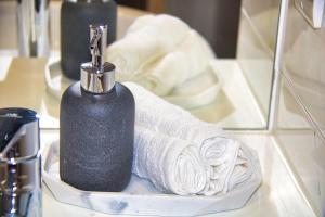 a black soap dispenser sitting on a counter with towels at AP- Luxury Apt nxt to o2 Academy in Birmingham