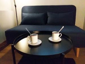 duas chávenas de café numa mesa em frente a um sofá em Le Paisible - Gare - Duplex - Garage privé - Netflix em Grenoble