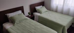 2 Betten nebeneinander in einem Zimmer in der Unterkunft Departamento Ambar in Cochabamba