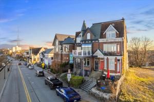 eine Reihe von Häusern in einer Stadtstraße mit Autos in der Unterkunft Skyline at Your Door - Studio with a View in Pittsburgh