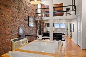 ein Wohnzimmer mit einer Ziegelwand und einem Tisch in der Unterkunft Skyline at Your Door - Studio with a View in Pittsburgh