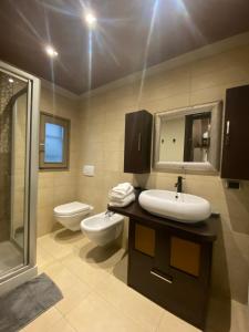 uma casa de banho com um lavatório, um WC e um espelho. em MILANO 11 em Arona
