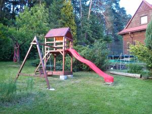 a playground with a red slide in a yard at Willa na Bani - apartamenty i pokoje in Rabka
