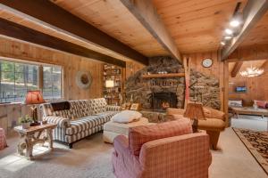 a living room with couches and a stone fireplace at Holly House on the West Shore - New Hot Tub, Wood Fireplace, Near Skiing in Tahoe City