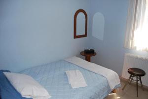 a blue bedroom with a bed and a stool at Guesthouse Kallisti in Anilio Pelion